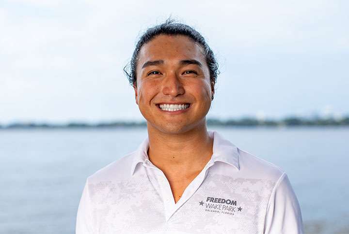 Smiling man in white shirt at lakeside