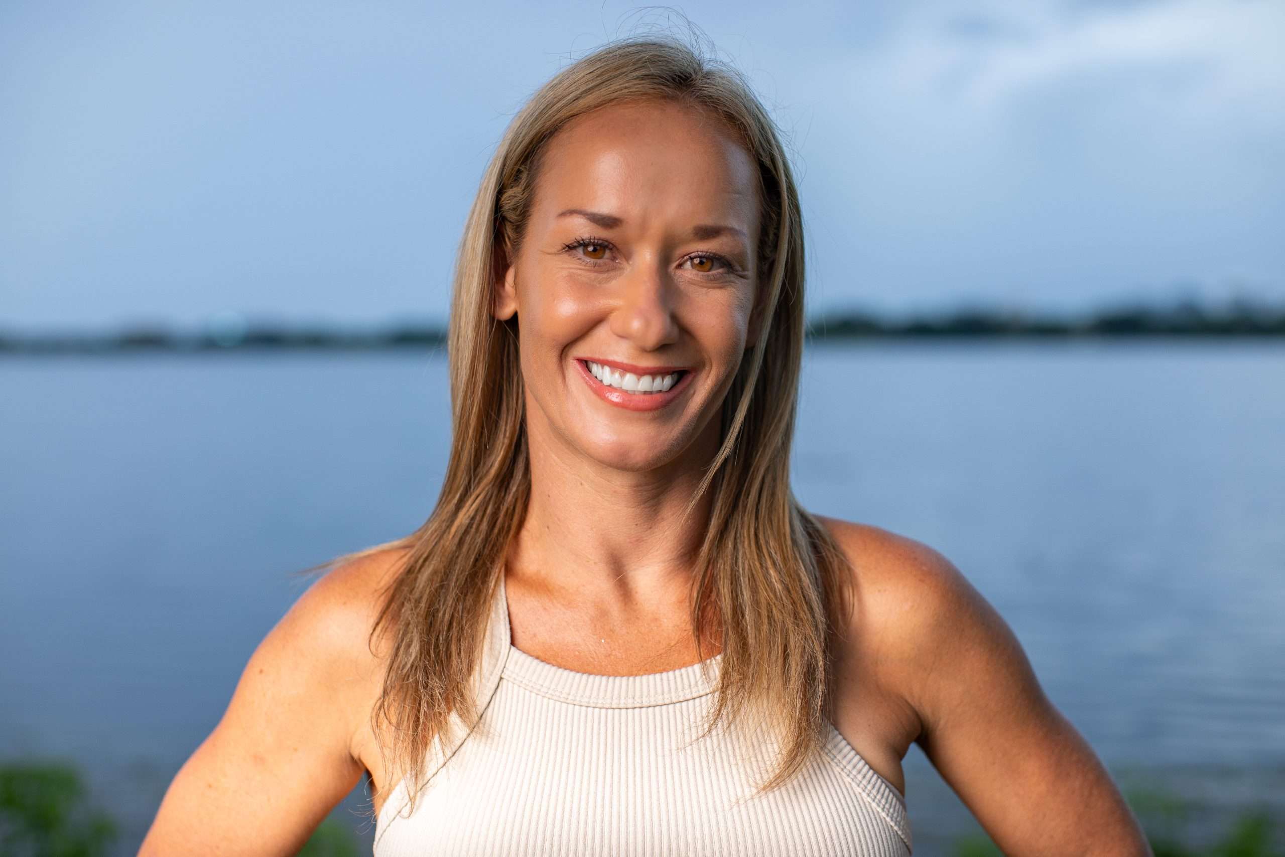 Smiling woman by lake at twilight