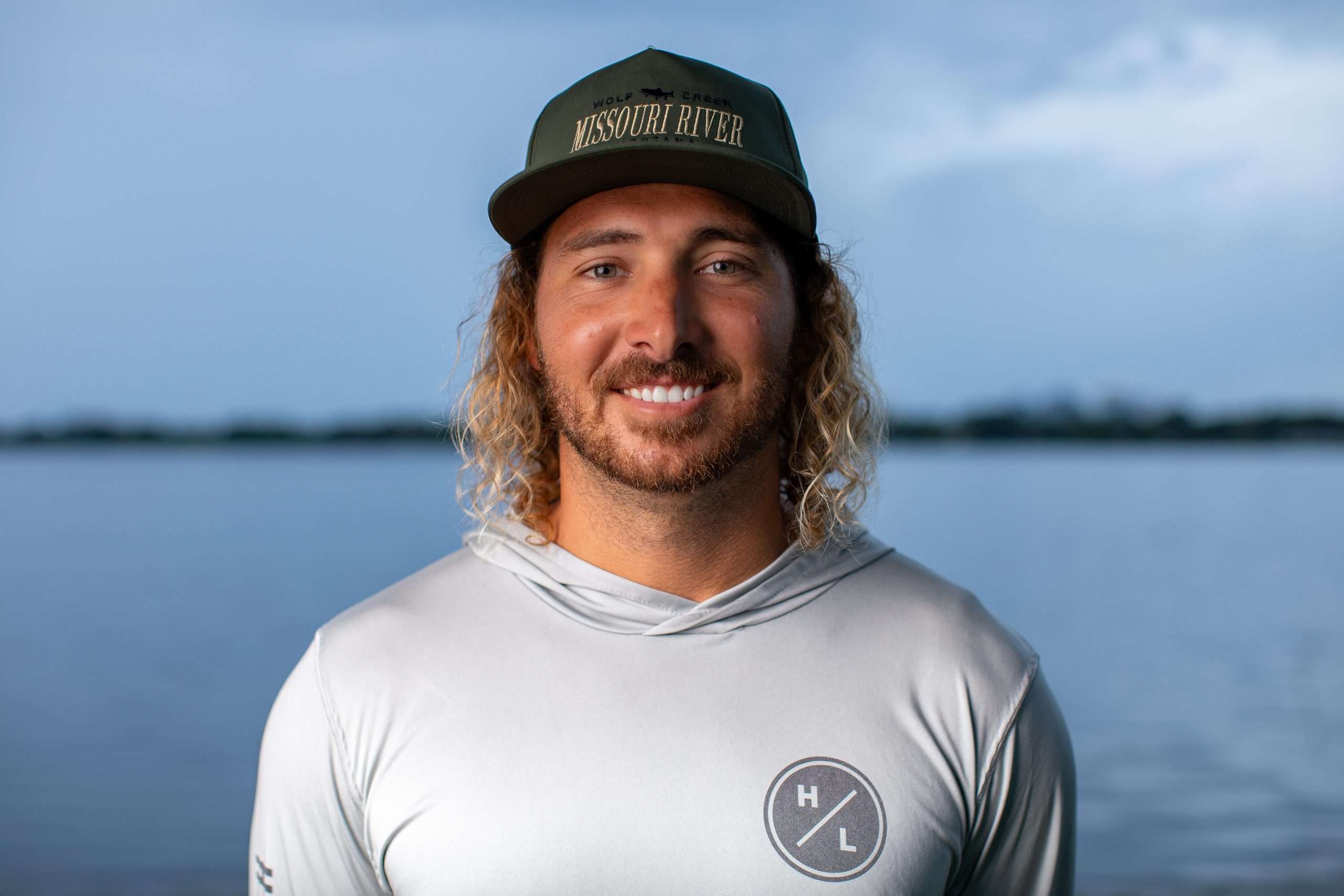 Smiling man in Missouri River hat by water