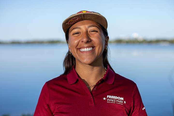 Happy woman in cap by lake at Freedom Wake Park