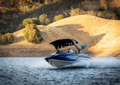 Speedboat cruising on lake near golden hills